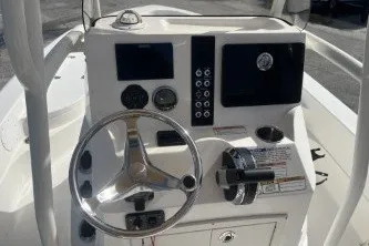 Slide: The Image of 2023 NauticStar 227 XTS boat console with steering wheel and control panel. - 9