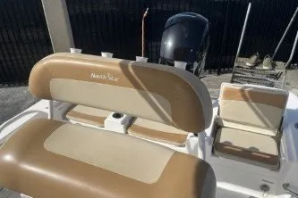 Slide: The Image of 2023 NauticStar 227 XTS boat interior with tan seating and motor. - 12
