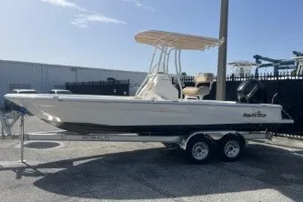 Slide: The Image of 2023 NauticStar 227 XTS boat on trailer, parked outdoors under clear sky. - 5