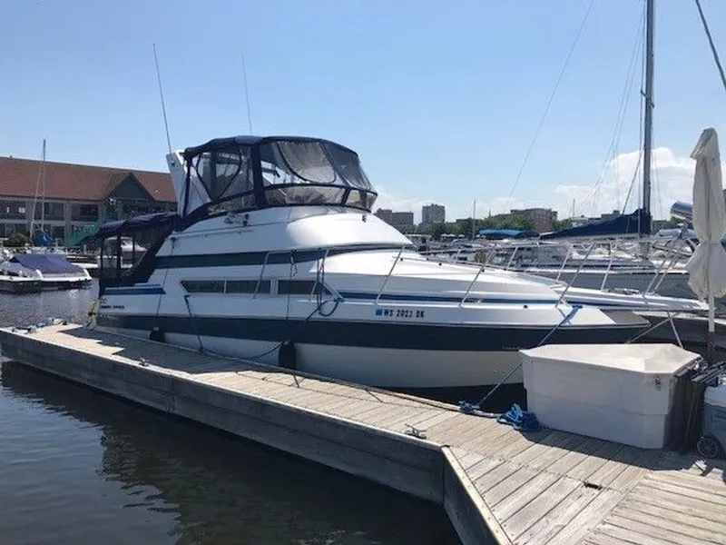 Slide: The Image of 1989 Carver 3067 Santego at dock with blue canopy and surrounding boats. - 1