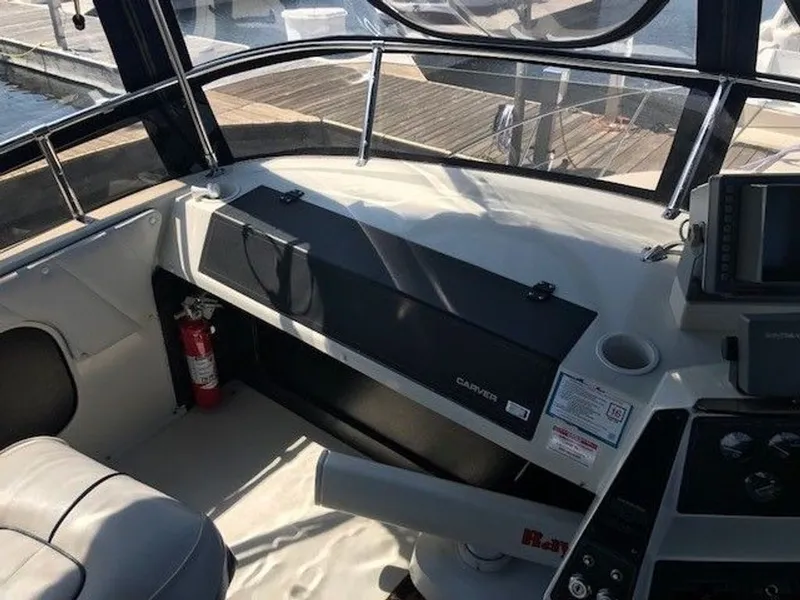 Slide: The Image of The cockpit of a 1989 Carver 3067 Santego with a helm console and fire extinguisher. - 2