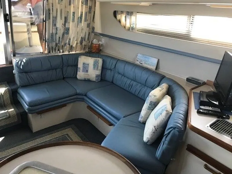 Slide: The Image of The image shows the interior of a 1989 Carver 3067 Santego with blue upholstery and a TV. - 11
