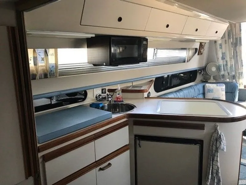 Slide: The Image of The galley of a 1989 Carver 3067 Santego with a microwave, sink, and refrigerator. - 8