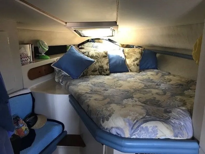 Slide: The Image of The image shows a cozy cabin with a large bed, decorated with blue and patterned pillows. - 13