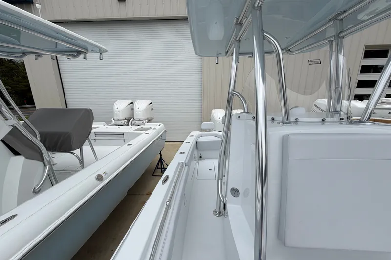 Slide: The Image of 2027 Contender 24 Sport boat with dual engines, parked near a garage door. - 8
