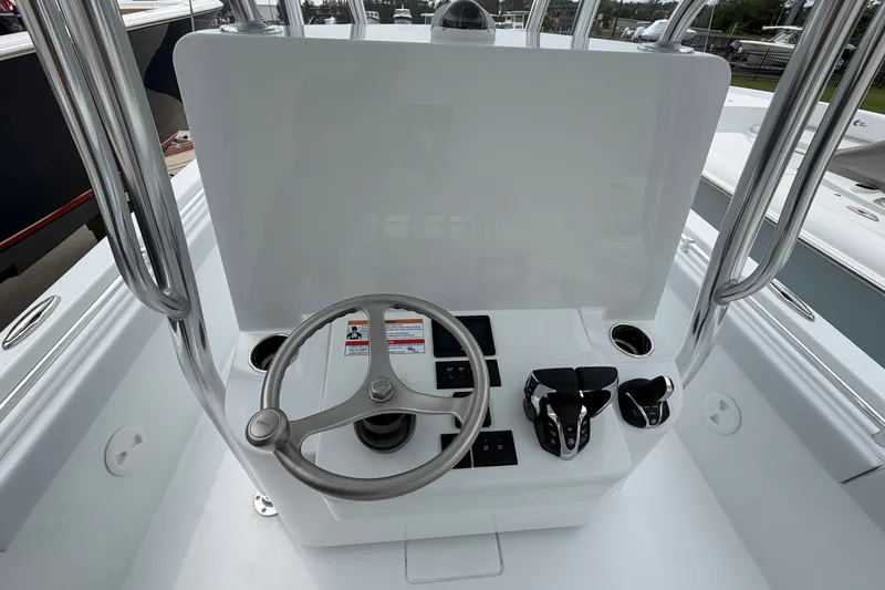 Slide: The Image of 2027 Contender 24 Sport boat helm with steering wheel and controls. - 10