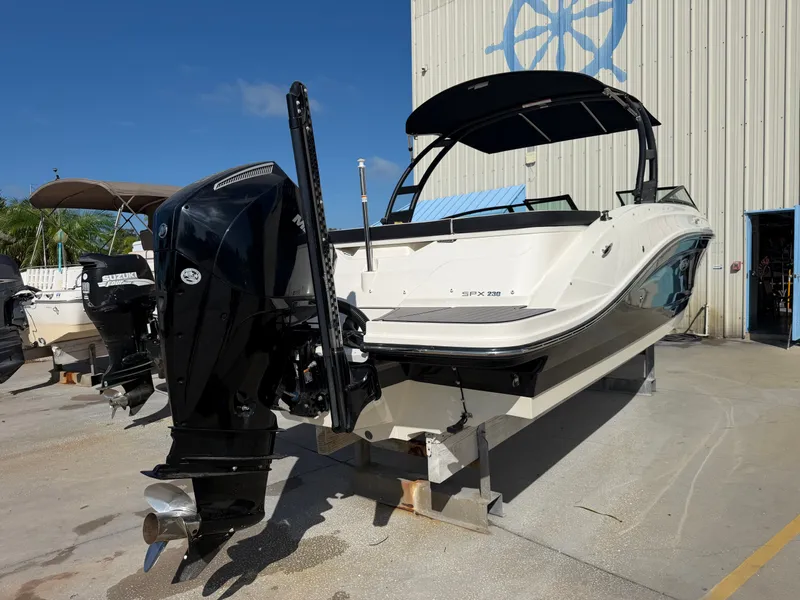 Slide: The Image of A 2022 Sea Ray SPX 230 Outboard is on a dry storage lot. The outboard motor is visible. - 2