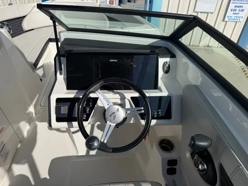 Slide: The Image of The cockpit of the Sea Ray SPX 230 Outboard features a modern steering wheel and large display. - 9