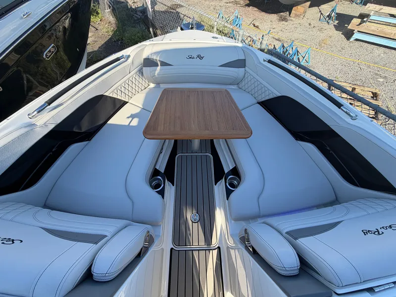 Slide: The Image of The image shows the bow area of a Sea Ray SLX 280 Outboard with sleek white upholstery and a wooden table. - 39