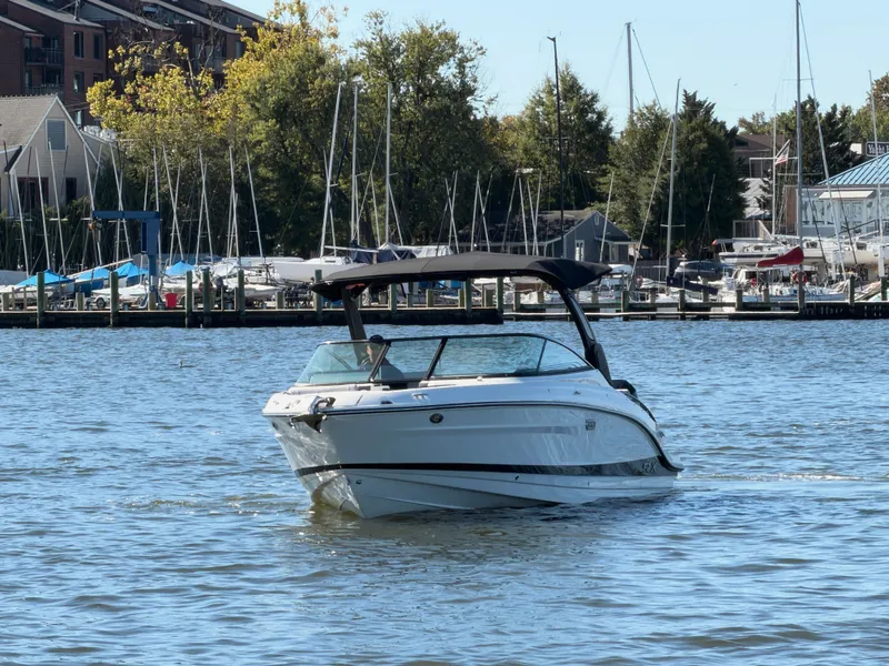 Slide: The Image of A 2027 Sea Ray SLX 280 Outboard cruising on calm waters, surrounded by a marina. - 2