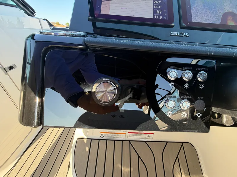 Slide: The Image of The image shows the dashboard of a Sea Ray SLX 280 Outboard with modern controls and screens. - 34