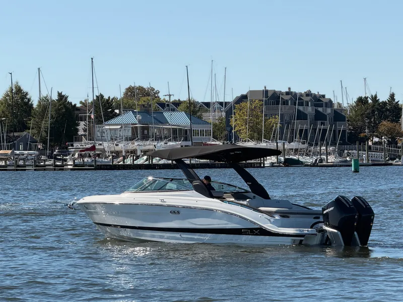Slide: The Image of 2027 Sea Ray SLX 280 Outboard on calm water near a marina. - 4