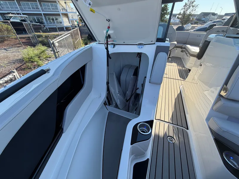 Slide: The Image of The image shows the cockpit of a 2027 Sea Ray SLX 280 Outboard with an open storage hatch. - 38