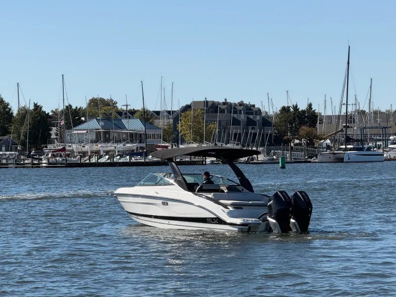 Slide: The Image of 2027 Sea Ray SLX 280 Outboard on calm water near a marina. - 5