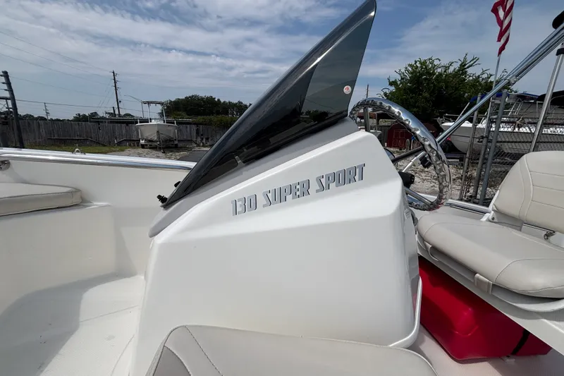 Slide: The Image of 2025 Boston Whaler 130 Super Sport boat interior with steering wheel and seating. - 25