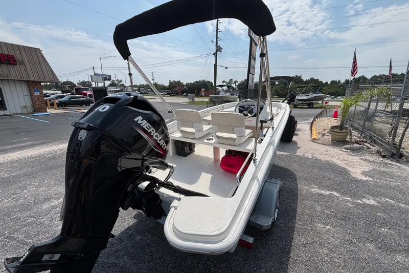 Slide: The Image of 2025 Boston Whaler 130 Super Sport boat with Mercury engine, parked outdoors. - 16