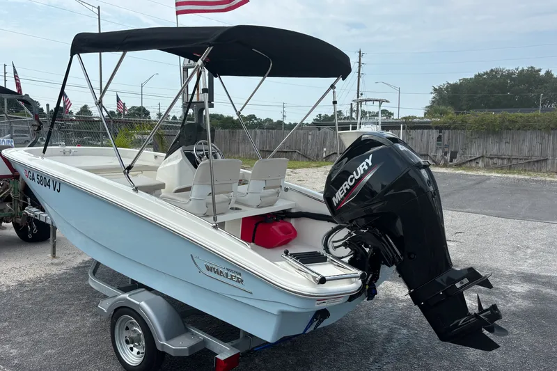 Slide: The Image of 2025 Boston Whaler 130 Super Sport boat with Mercury engine on trailer. - 2