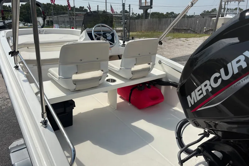 Slide: The Image of 2025 Boston Whaler 130 Super Sport boat interior with Mercury engine, showcasing seating and controls. - 15