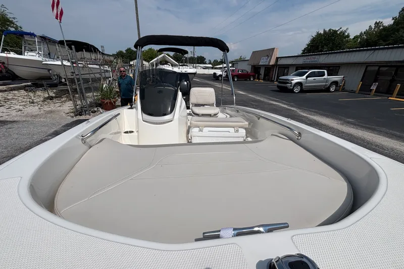 Slide: The Image of 2025 Boston Whaler 130 Super Sport boat at a dealership, showcasing interior seating and console. - 22