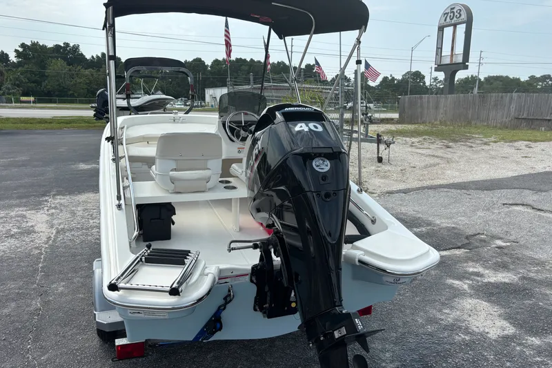 Slide: The Image of 2025 Boston Whaler 130 Super Sport boat with Mercury 40 engine, parked outdoors. - 3