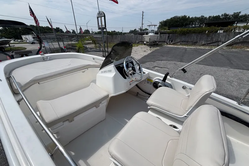 Slide: The Image of 2025 Boston Whaler 130 Super Sport boat interior with seating and steering wheel. - 27