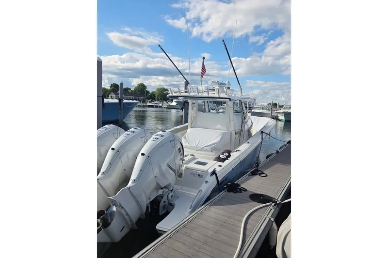 Slide: The Image of 2023 Pursuit S 378 Sport boat docked with triple outboard engines. - 7