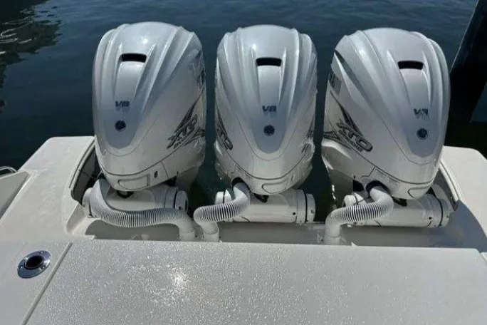 Slide: The Image of Triple V8 engines on a 2023 Pursuit S 378 Sport boat, docked on calm water. - 10