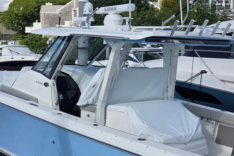 Slide: The Image of 2023 Pursuit S 378 Sport boat docked, featuring sleek design and advanced Garmin navigation. - 5