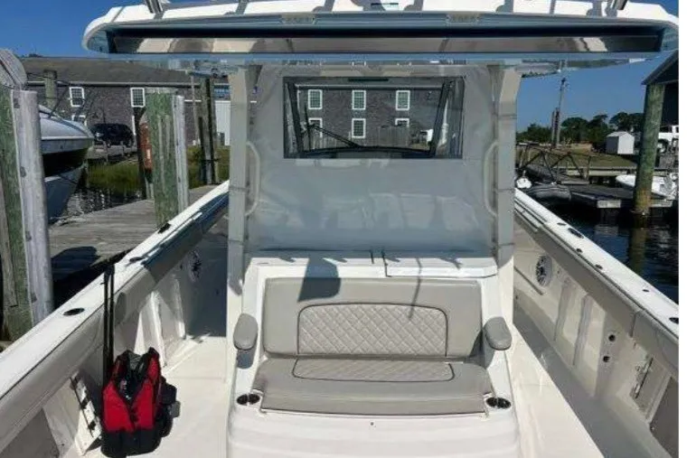 Slide: The Image of 2023 Pursuit S 378 Sport boat with cushioned seating at a marina dock. - 17
