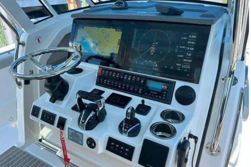 Slide: The Image of Control panel of 2023 Pursuit S 378 Sport boat with navigation screens and steering wheel. - 14