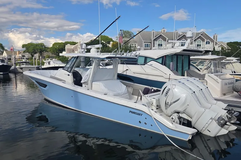 Slide: The Image of 2023 Pursuit S 378 Sport boat docked at marina, featuring sleek design and powerful engines. - 1