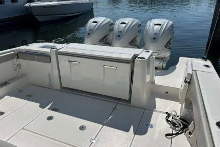 Slide: The Image of 2023 Pursuit S 378 Sport boat with triple outboard engines docked on water. - 13
