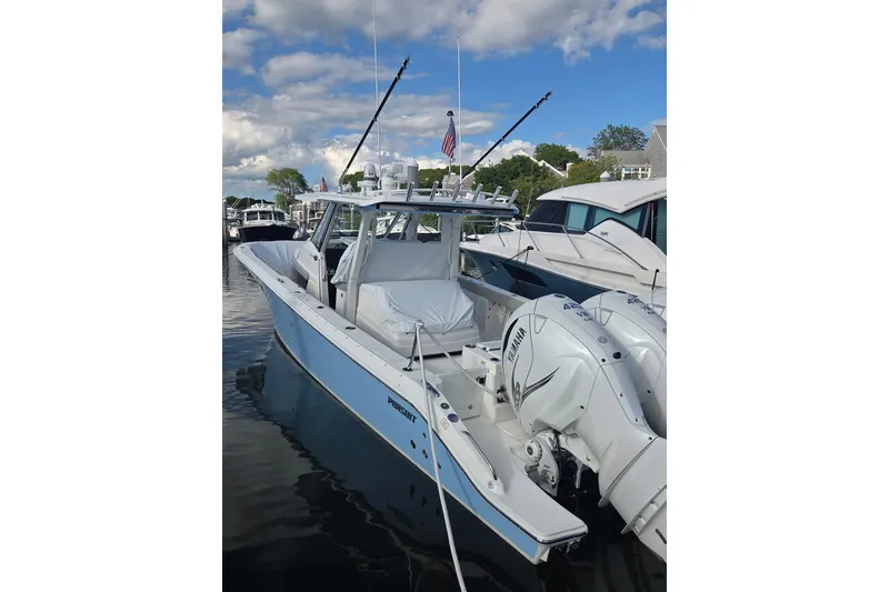 Slide: The Image of 2023 Pursuit S 378 Sport boat docked, featuring twin Yamaha engines under a blue sky. - 6