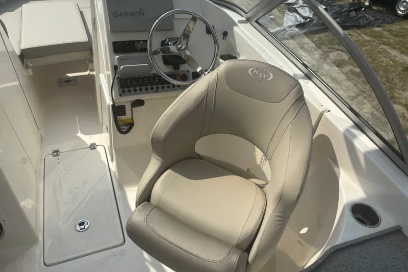 Slide: The Image of 2023 Key West 239 DFS boat interior with steering wheel and beige seating. - 30