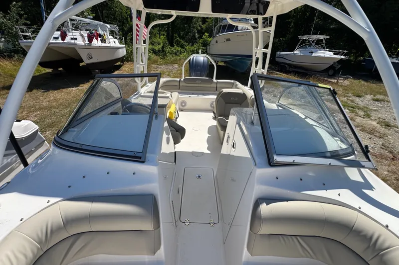 Slide: The Image of 2023 Key West 239 DFS boat interior with seating and windshield, parked outdoors. - 11