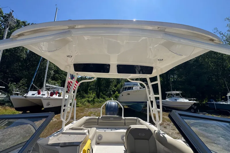 Slide: The Image of 2023 Key West 239 DFS boat interior with canopy, parked among other boats. - 12
