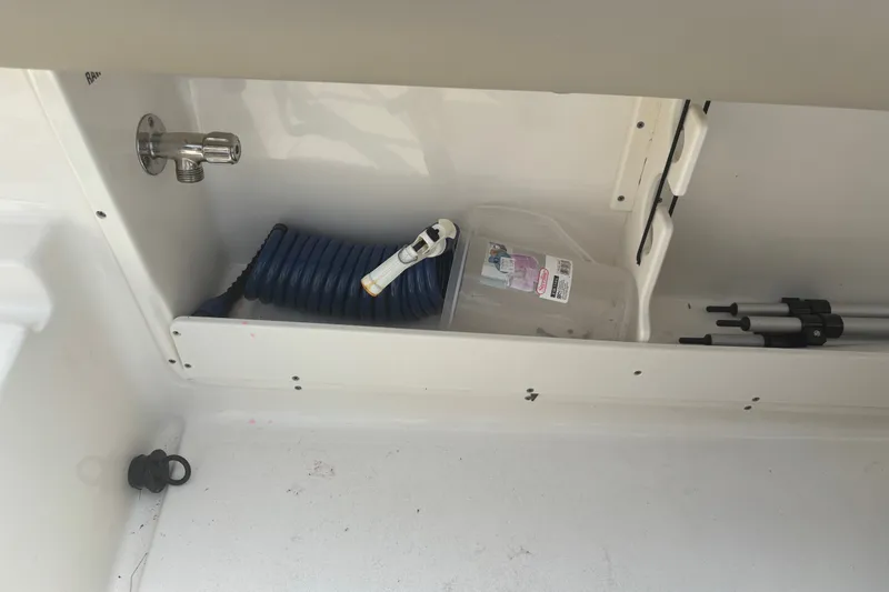 Slide: The Image of Storage compartment of 2023 Key West 239 DFS boat with hose and container. - 43