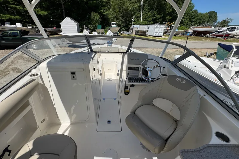 Slide: The Image of 2023 Key West 239 DFS boat interior with steering wheel and seating area. - 6