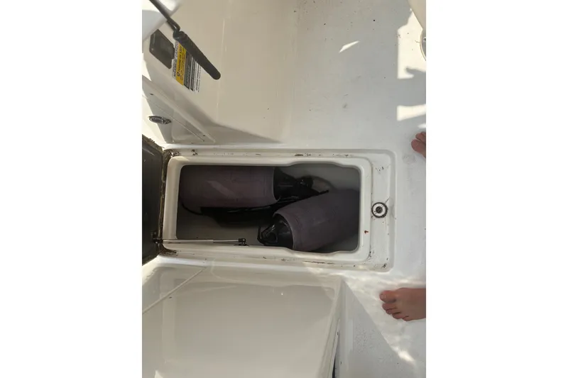 Slide: The Image of Storage compartment on a 2023 Key West 239 DFS boat, containing fenders. - 44