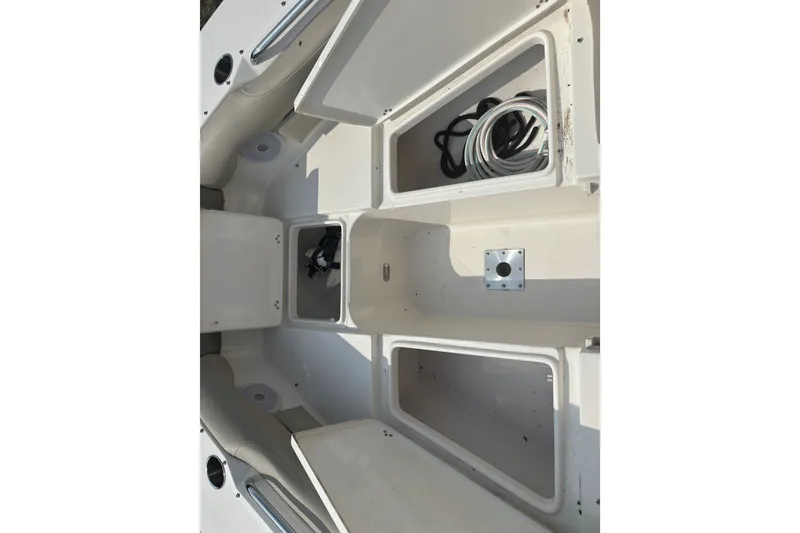 Slide: The Image of 2023 Key West 239 DFS boat storage compartments with open hatches and coiled ropes. - 46