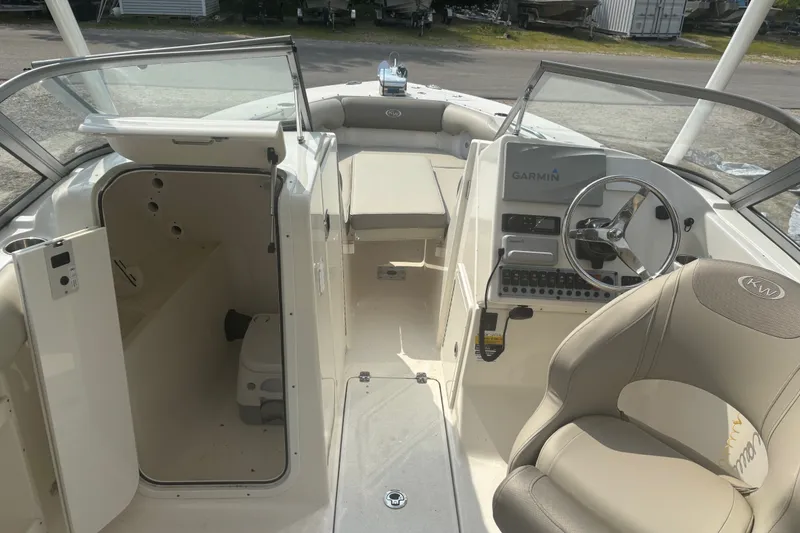 Slide: The Image of 2023 Key West 239 DFS boat interior with helm, seating, and storage area. - 23