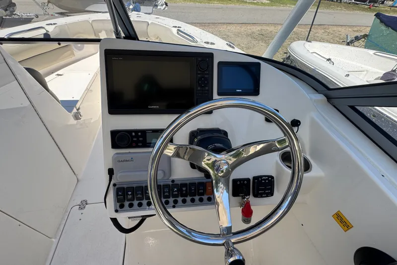 Slide: The Image of 2023 Key West 239 DFS boat dashboard with Garmin navigation system and steering wheel. - 7