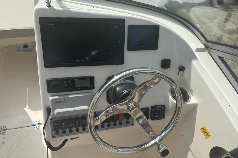 Slide: The Image of 2023 Key West 239 DFS boat dashboard with Garmin navigation and steering wheel. - 31