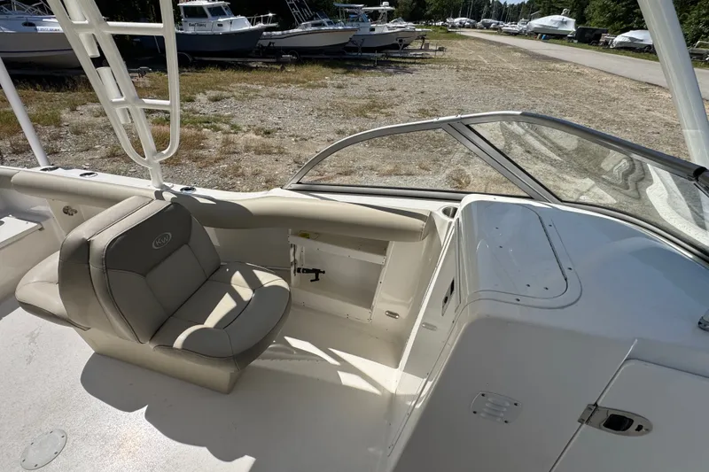Slide: The Image of 2023 Key West 239 DFS boat interior with seating and storage, parked outdoors. - 5