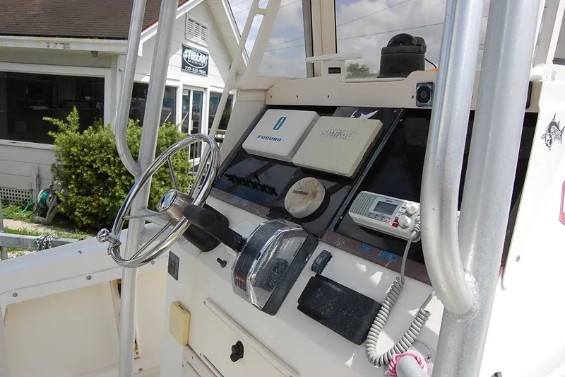 Slide: The Image of 1992 Mako 221 Center Console boat dashboard with steering wheel and navigation equipment. - 11