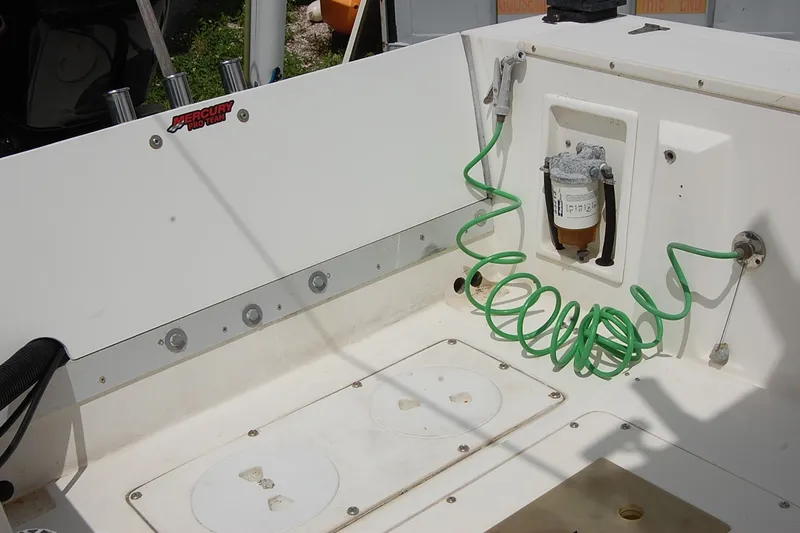Slide: The Image of 1992 Mako 221 Center Console boat deck with Mercury Pro Team logo and green coiled hose. - 9