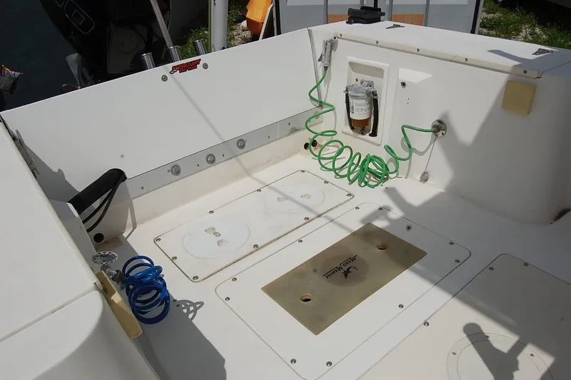 Slide: The Image of 1992 Mako 221 Center Console boat deck with storage compartments and coiled hoses. - 10