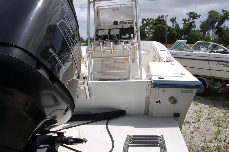 Slide: The Image of 1992 Mako 221 Center Console boat with Mercury engine, docked outdoors. - 5