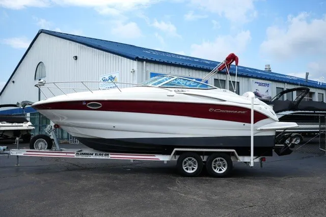 The Image of 2008 Crownline 250 CR boat on trailer, parked outside a marine dealership. - 1