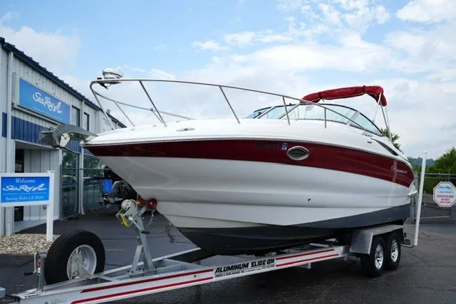 Slide: The Image of 2008 Crownline 250 CR boat on trailer, parked outside a marine dealership. - 2